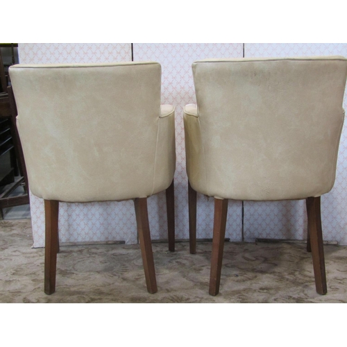 2219 - A pair of mid 20th century office chairs with cream brown rexine upholstery on moulded supports