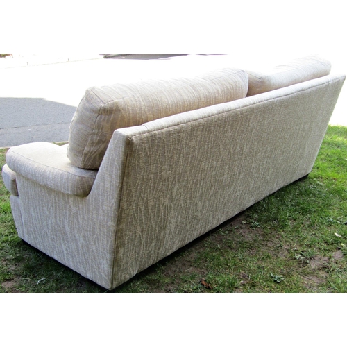 2235 - A three seat sofa, cream ground with repeating reed patterned upholstery, with loose squab cushions,... 