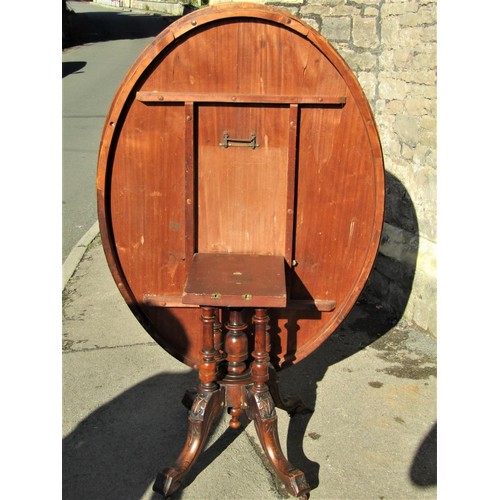 2238 - A Victorian walnut loo table, the oval top raised on a platform base with turned column supports and... 