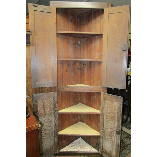 2352 - A Georgian oak country made freestanding corner cupboard enclosed by two pairs of panelled doors and... 