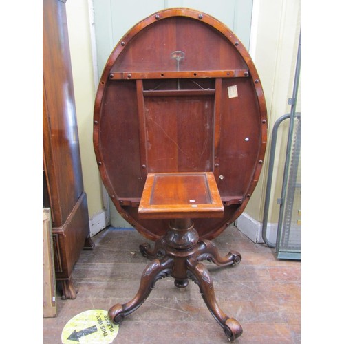 2358 - A Victorian figured walnut  loo table, the oval top quarter veneered, raised on a carved pillar and ... 