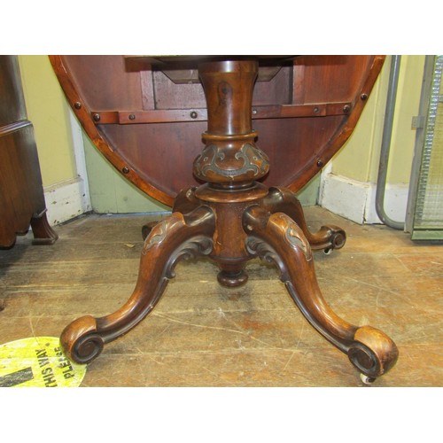 2358 - A Victorian figured walnut  loo table, the oval top quarter veneered, raised on a carved pillar and ... 