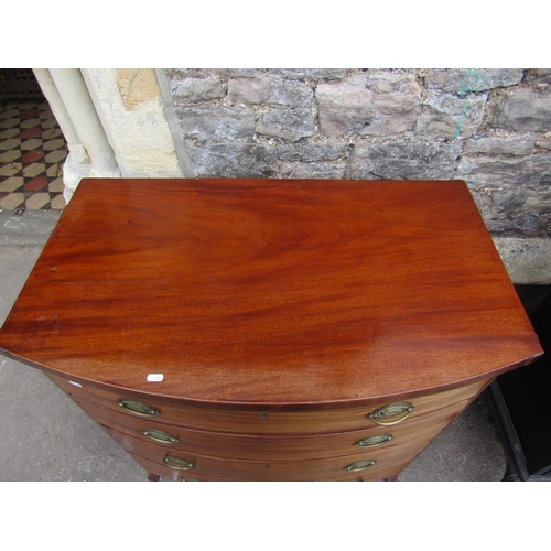 2360 - A small Georgian  mahogany bow fronted chest of four long drawers on swept supports with embossed br... 