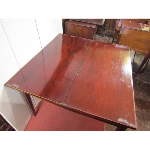 2364 - A Georgian mahogany fold over top table of rectangular form raised on four square taper supports wit... 