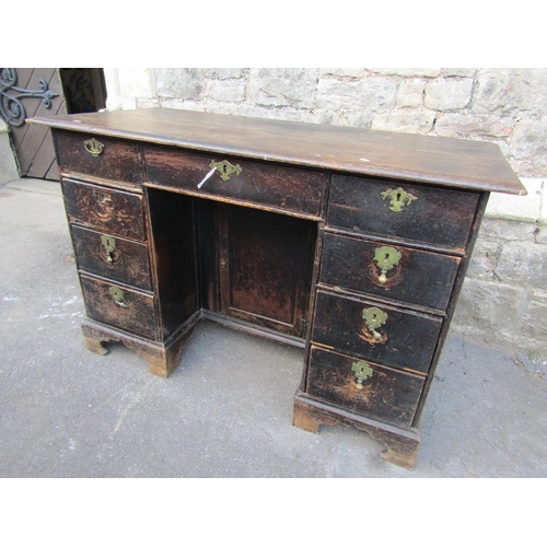 2365 - A Georgian oak kneehole writing desk fitted with nine drawers with central recess cupboard and raise... 