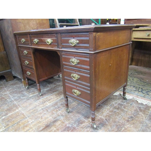 2369 - An Edwardian mahogany writing desk fitted with nine drawers on turned supports with inset top, pen t... 