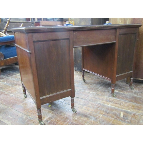 2369 - An Edwardian mahogany writing desk fitted with nine drawers on turned supports with inset top, pen t... 