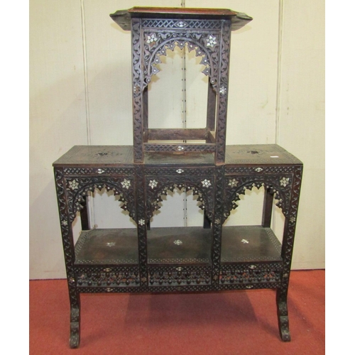 2396 - A Moroccan occasional table on three tiers with carved finish and mother of pearl inlaid detail