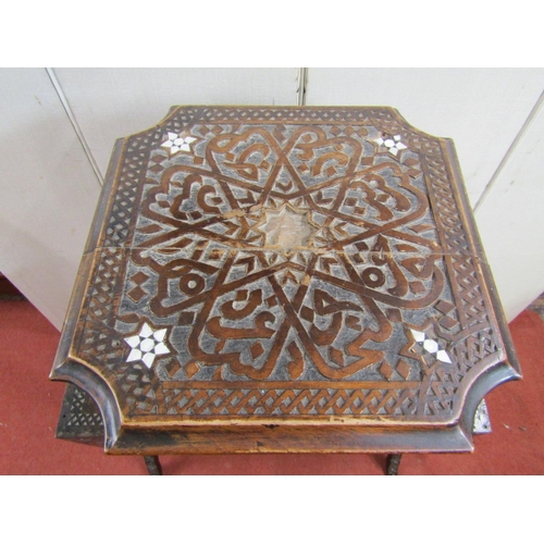 2396 - A Moroccan occasional table on three tiers with carved finish and mother of pearl inlaid detail