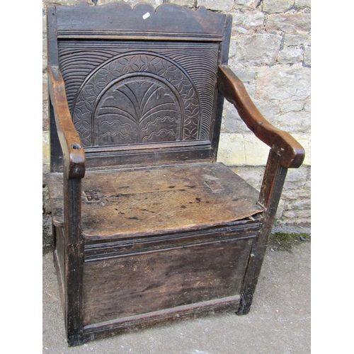 2405 - A late 17th century oak wainscot chair with box seat, the back with carved detail, set beneath a sha... 