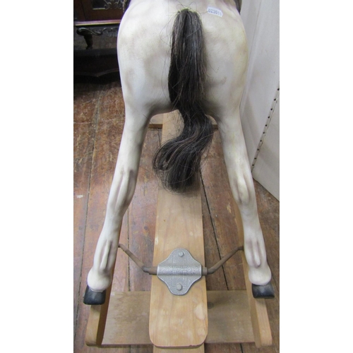 2409 - A carved timber dapple grey rocking horse raised on a central rocker, 110cm high approx max