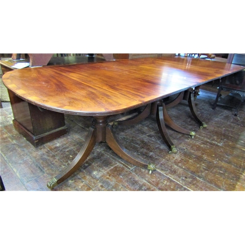 2414 - A Georgian style mahogany three pedestal dining table on turned columns and reeded sabre supports, t... 