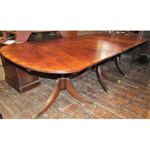 2414 - A Georgian style mahogany three pedestal dining table on turned columns and reeded sabre supports, t... 