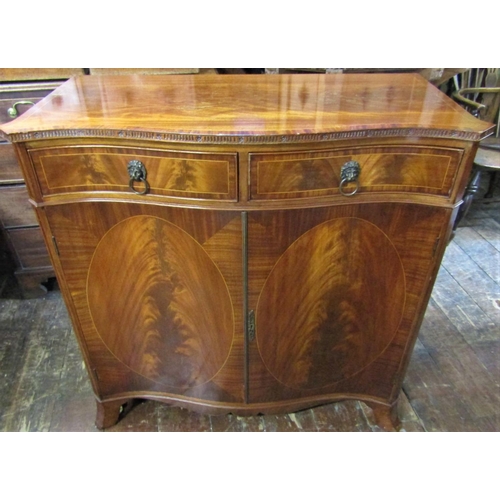 2425 - A good quality reproduction serpentine side cabinet enclosed by two panelled doors and two drawers, ... 