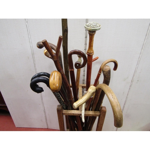 2443 - An oak four divisional stickstand enclosing a mixed arrangement of walking sticks, riding crops, etc