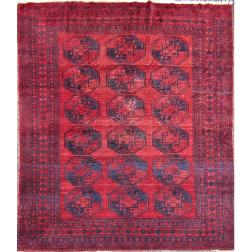 2462 - A large Afghan designed carpet with a central panel of elephant feet on a red ground. 310cm x 230cm ... 