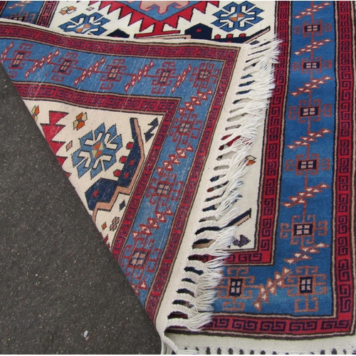 2465 - A Kazak style rug with three central medallions. 170cm x 100cm