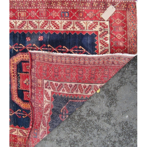 2467 - A Middle Eastern corridor rug, with a central row of gul and elephant foot medallions on a blue grou... 