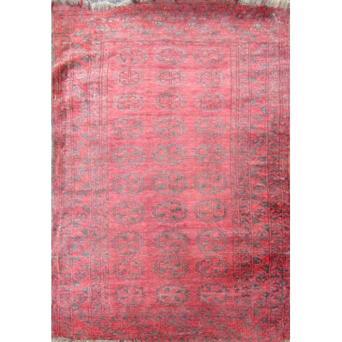 2468 - A Turkoman carpet with three rows of medallions on a red ground. 180cm x 125cm