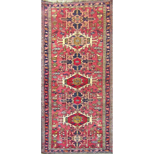 2502 - A Hamadan runner with sevens central medallions and stylised bird on a red ground. 190cm x 72cm