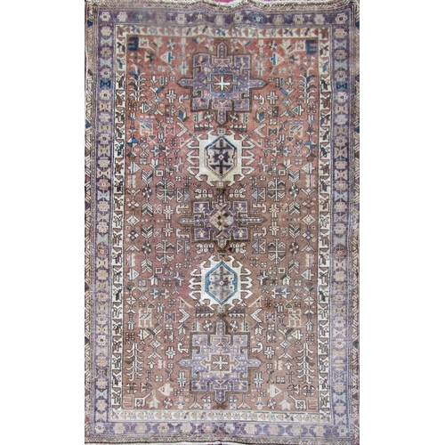 2503 - A Heriz rug with a pale brown field of geometric designs. 180cm x 105cm approx.