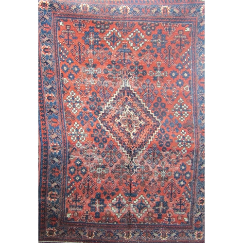 2505 - A Josheghan rug with a geometric pattern and stylised flowers on an orange ground. 190cm x 135cm app... 