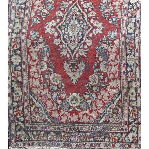 2514 - A middle eastern design carpet with a central floral medallion upon a red ground, 200cm x 140cm