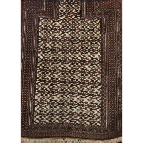 2515 - A Meshed Baluchi prayer mat, with repeating geometric black and brown pattern, 134cm x 94cm