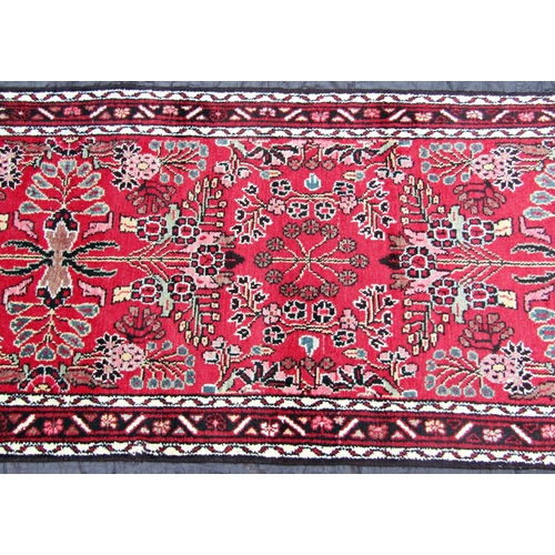 2519 - A Malayer runner with overall floral pattern on a red ground, 400 x 83cm