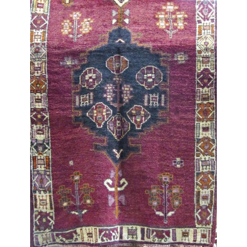 2524 - A Kurdish Kelleh with central blue medallion upon a purple ground, 410cm x 145cm