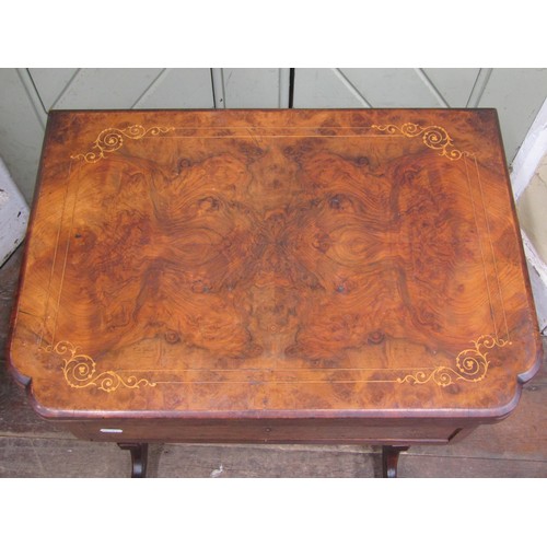 2412a - A Victorian walnut fold over top games\sewing table with inlaid detail raised on turned and swept su... 