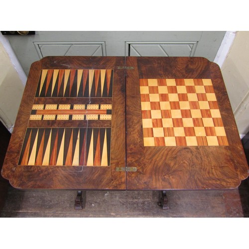 2412a - A Victorian walnut fold over top games\sewing table with inlaid detail raised on turned and swept su... 