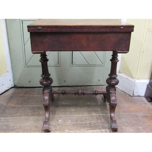 2412a - A Victorian walnut fold over top games\sewing table with inlaid detail raised on turned and swept su... 