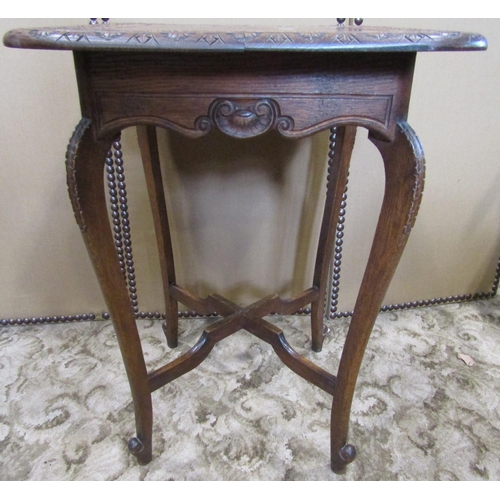 2138 - An Edwardian oak occasional table, the overhanging square top with rounded corners and carved repeat... 