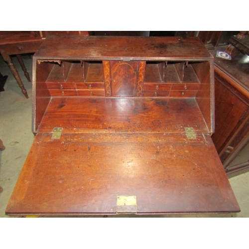 2282B - A Georgian mahogany bureau, the fall flap enclosing a fitted interior of small drawers and pigeon ho... 