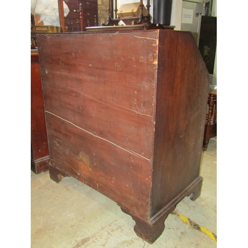 2282B - A Georgian mahogany bureau, the fall flap enclosing a fitted interior of small drawers and pigeon ho... 