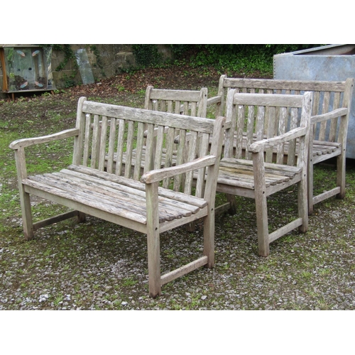 2015 - A weathered hardwood four piece garden suite comprising a pair of two seat benches with slatted back... 