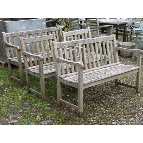 2015 - A weathered hardwood four piece garden suite comprising a pair of two seat benches with slatted back... 