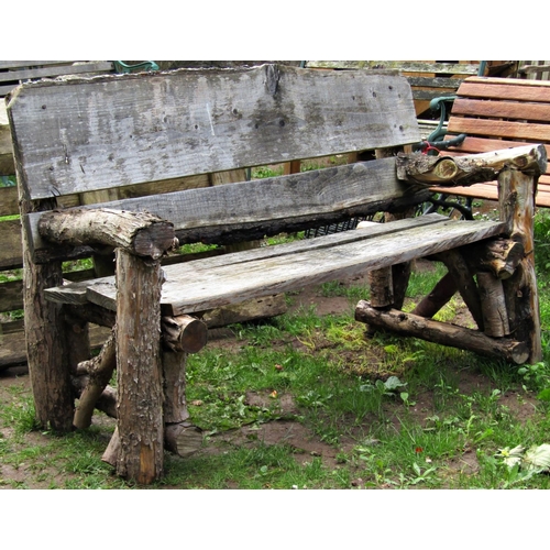 2042 - A weathered rustic rough hewn wooden garden bench, 155 cm wide approximately