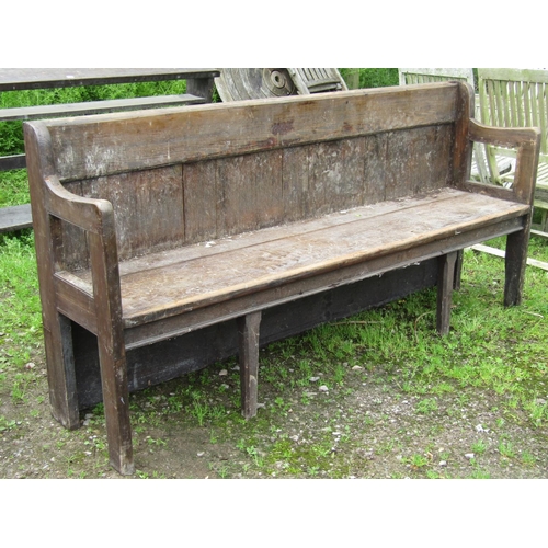 2058 - A stained pine chapel bench with open shaped and moulded arms, panelled back, chamfered legs, 190 cm... 