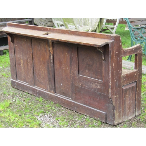 2059 - A stained pine chapel bench with open shaped and moulded arms, panelled back, chamfered legs, 190 cm... 