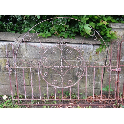 2063 - A pair of low decorative ironwork arched entrance gates with open scroll work detail, 305 cm wide (1... 