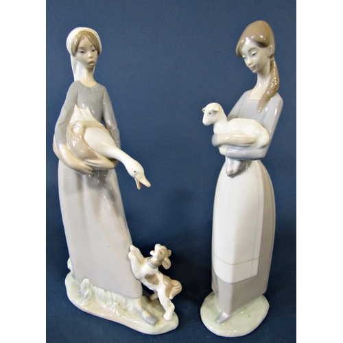 70 - Five Lladro figures of young girls comprising one holding a lamb, another holding a goose with a dog... 