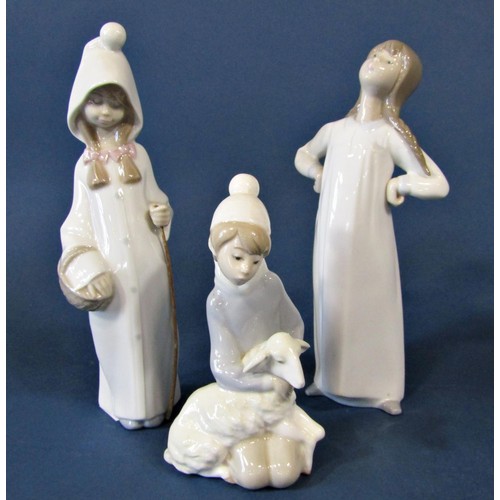 70 - Five Lladro figures of young girls comprising one holding a lamb, another holding a goose with a dog... 