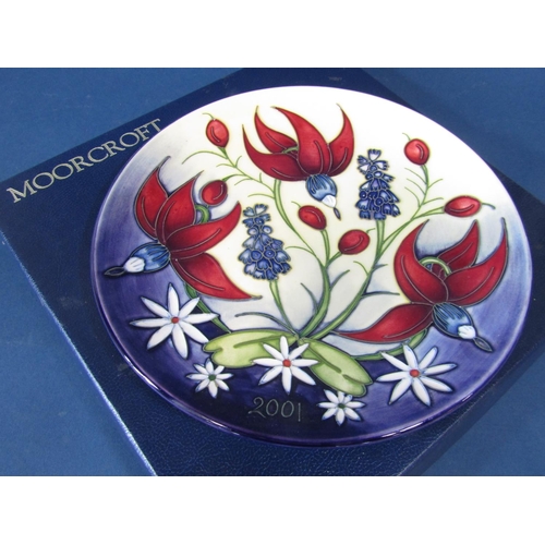 89 - A Moorcroft Pottery year plate decorated with red lilies, cosmos and bluebells and date 2001, limite... 