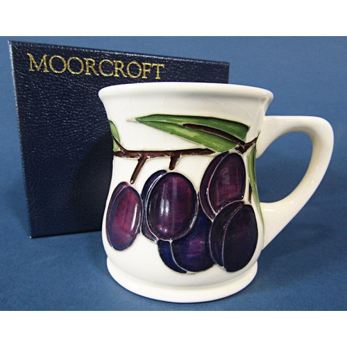 68 - A Moorcroft Pottery 'Plum' pattern mug, designed by Sally Tuffin for Liberty, 9cm tall approx, stamp... 