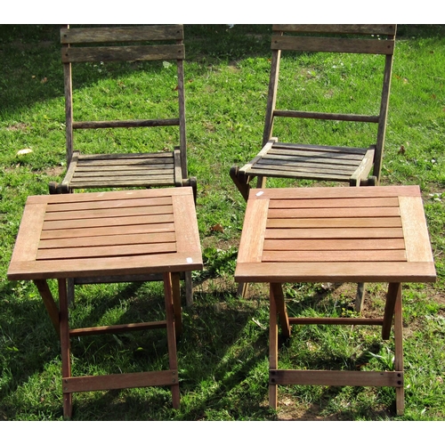 1045 - A pair of weathered hardwood folding garden chairs with slatted seats and backs together with a pair... 