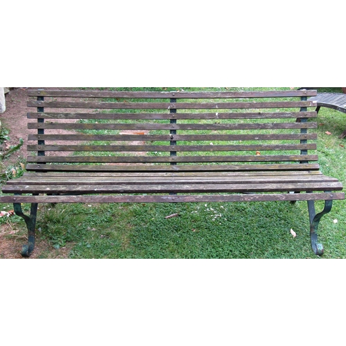 1059 - A vintage garden bench with weathered timber slatted seat and combined back raised on sprung steel s... 