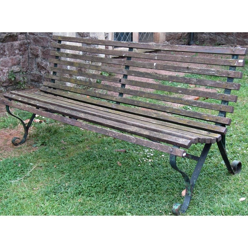 1059 - A vintage garden bench with weathered timber slatted seat and combined back raised on sprung steel s... 