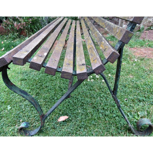 1059 - A vintage garden bench with weathered timber slatted seat and combined back raised on sprung steel s... 